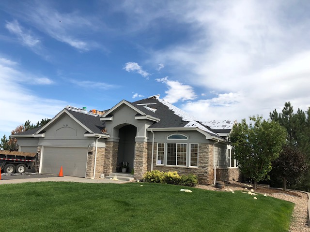 Denver storm damage roof repair under construction once hail roof damage insurance claim is approved.
